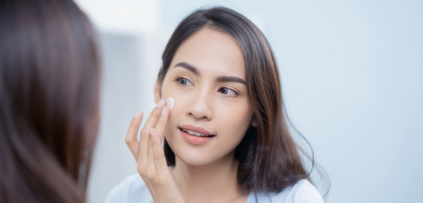 woman putting cream in front of glass